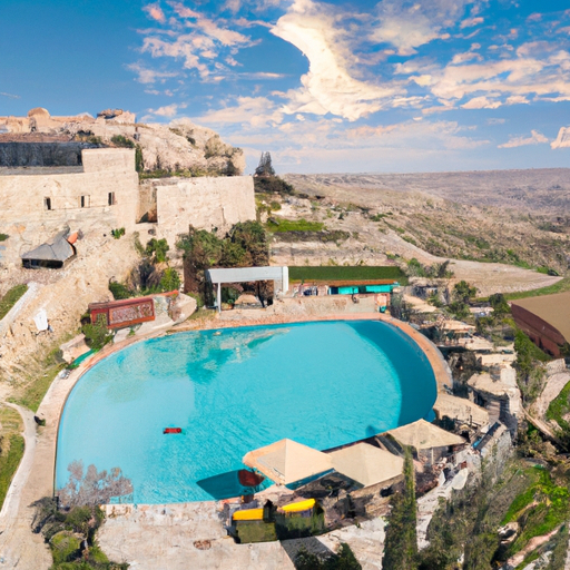 נוף פנורמי של מלון מצודת דוד המציג את הארכיטקטורה המדהימה שלו ואת אזור הבריכה.
